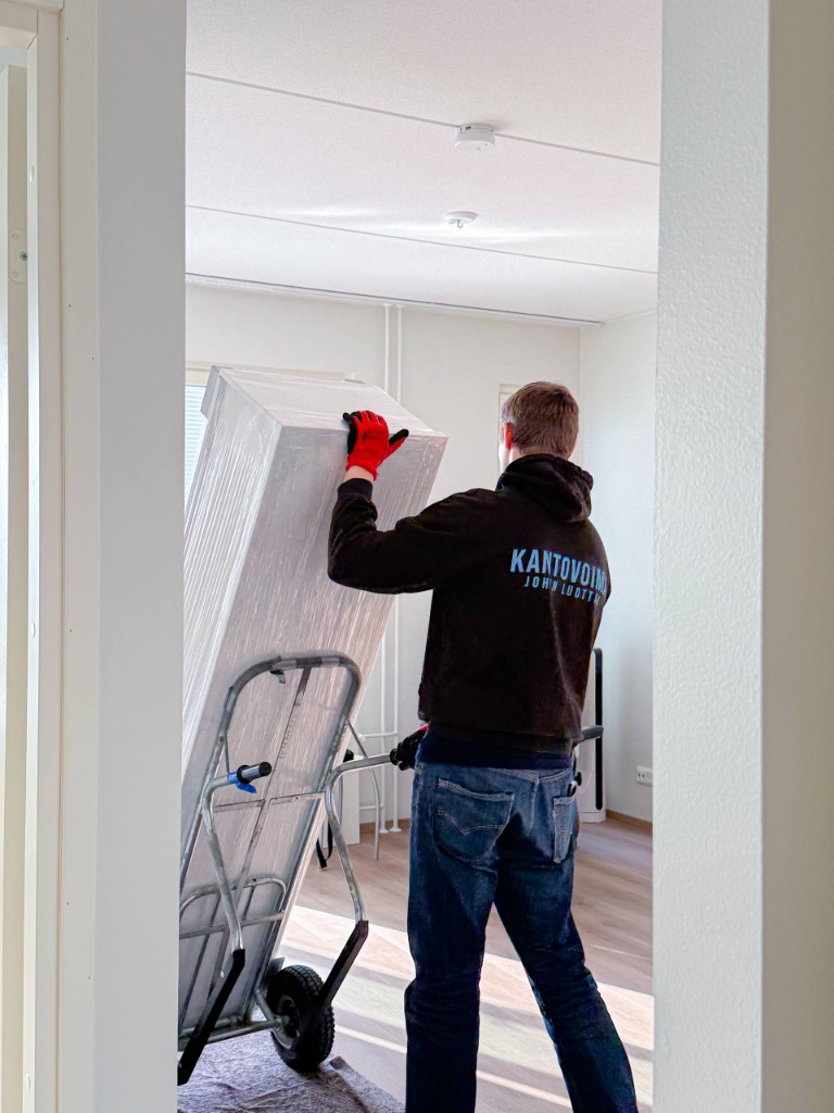 Kantovoiman muuttaja kuljettaa kalusteen nokkakärryillä sisätiloissa