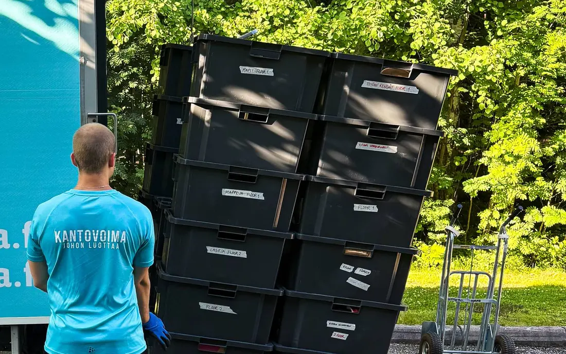 A Kantovoima worker beside a stack of moving crates on the truck tail lift